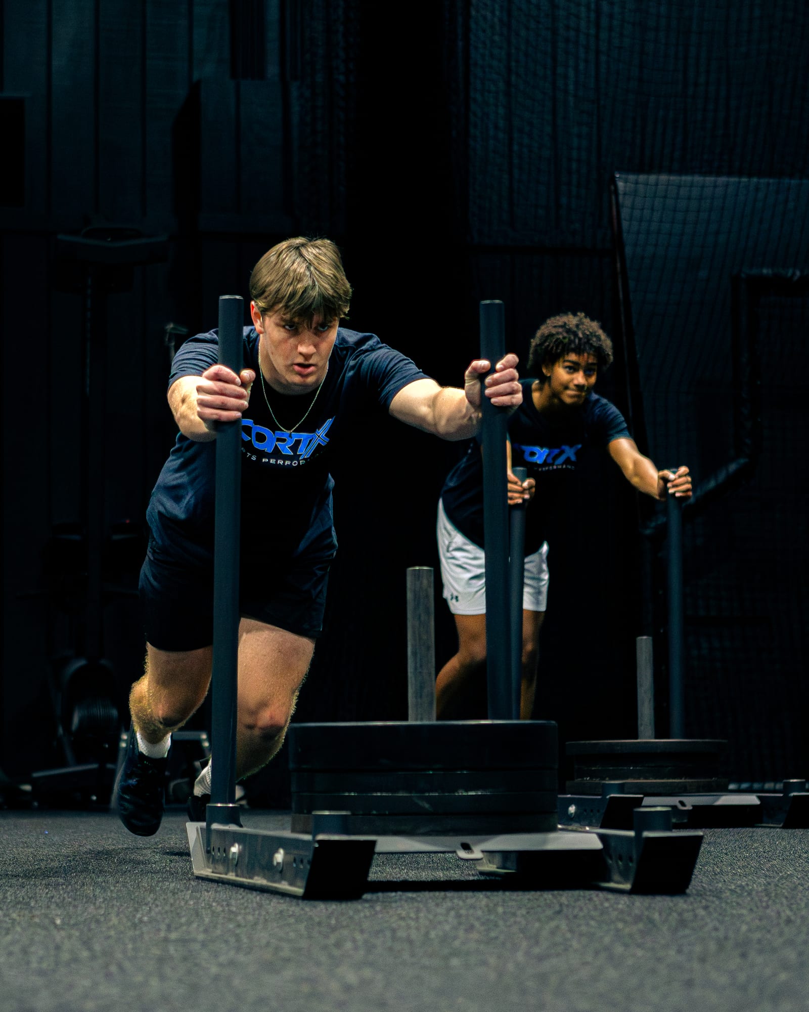 Athletes pushing a weighted sled